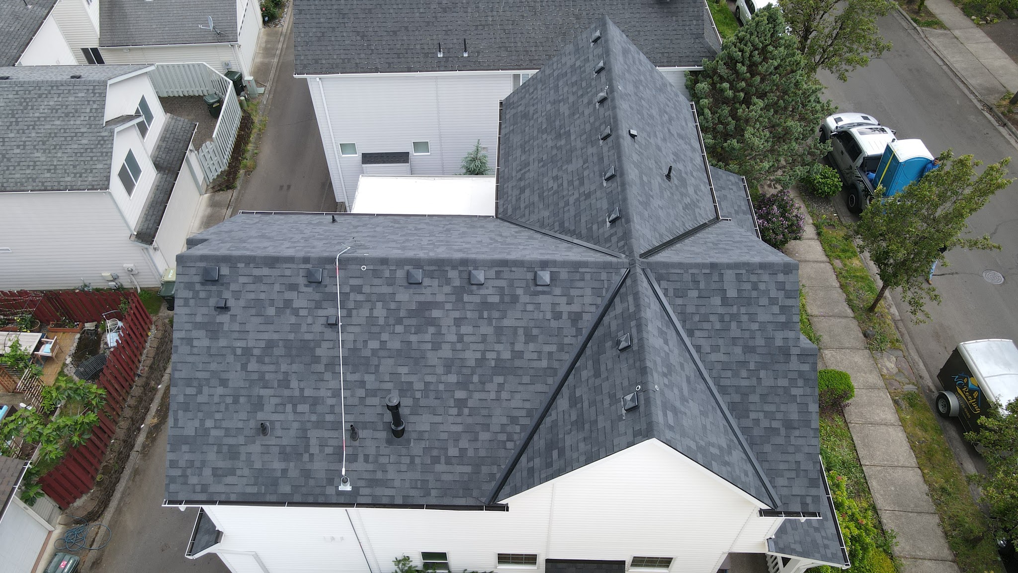 Aerial view of a completed shingle roof, adjoining townhomes