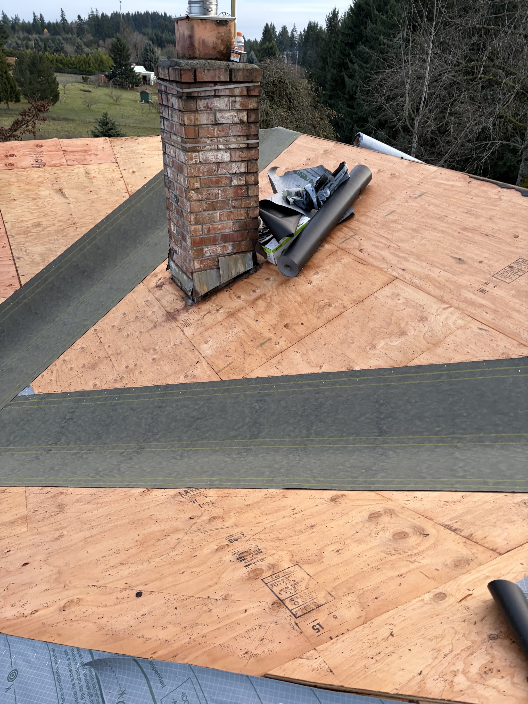 Aerial detail of finished shingle roofline meeting at the ridge