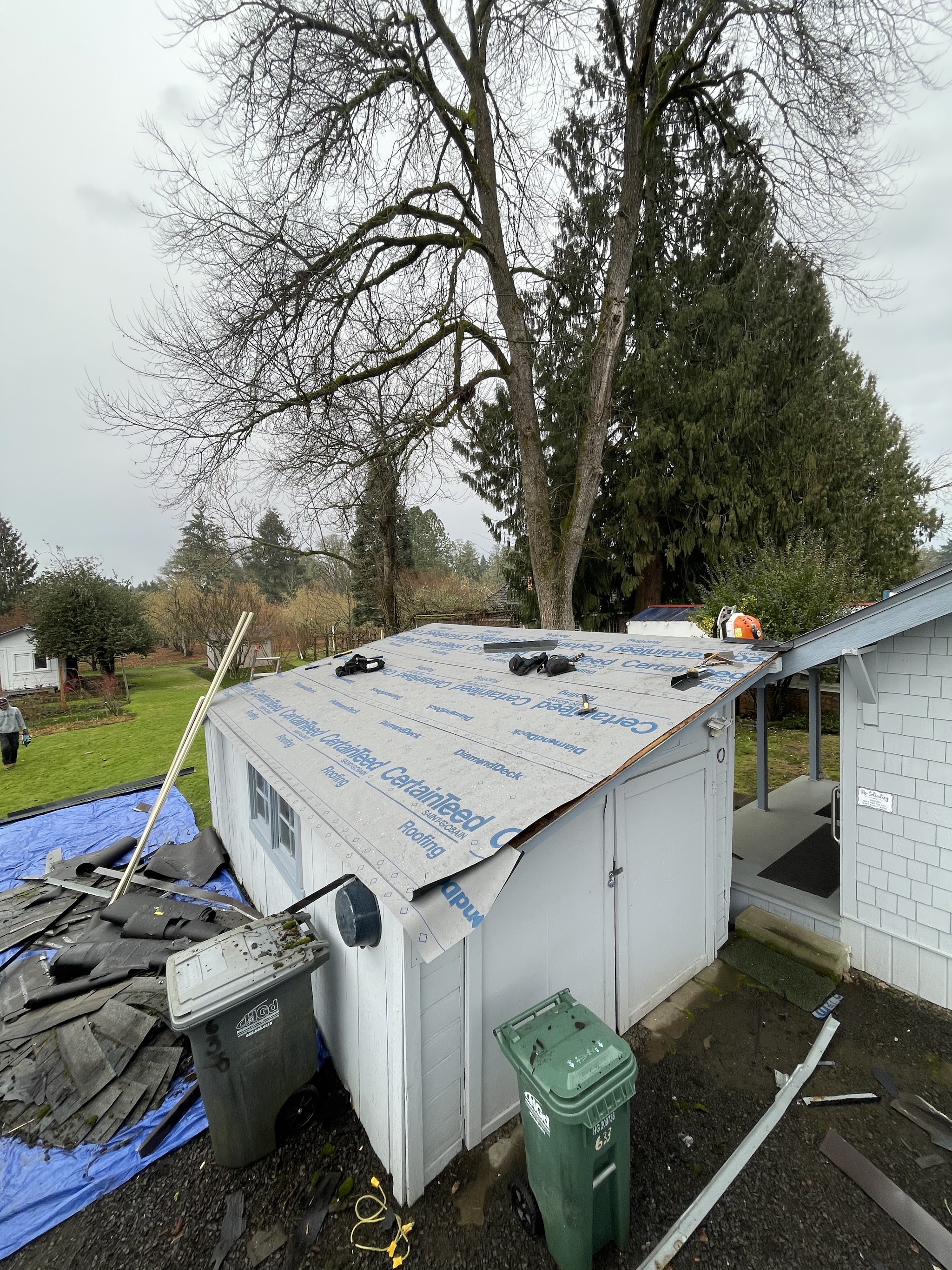 Completed roof replacement on a two-tone blue and red two-story home