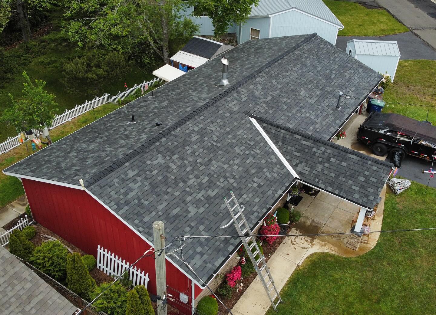 Aerial view of a finished dark shingle roof on a barn-style building