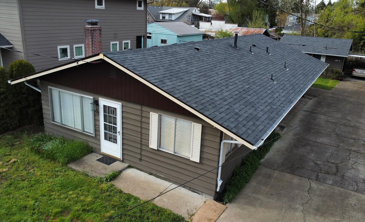 Aerial view of a finished dark shingle roof on a ranch-style home